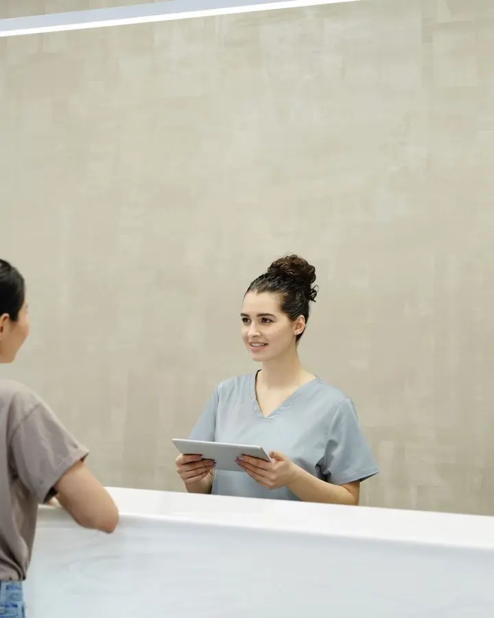 A receptionist greeting a client at the front desk.